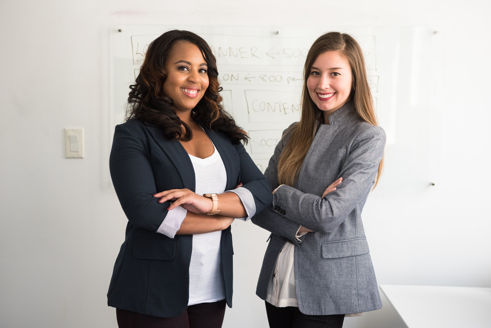 #WOCIT Two women standing in front of whiteboard with web design text written on it
