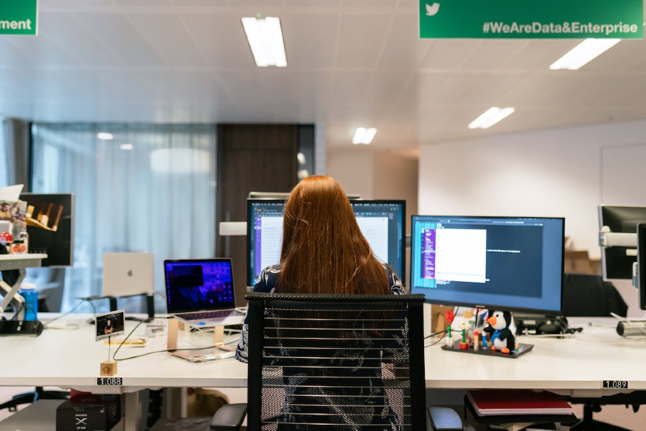 Woman working in front of three computer screens