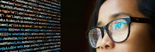 girl looking at code with reflection in glasses