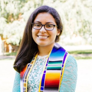 Profile picture of Maritza with rainbow scarf around neck and trees in background Women In Tech